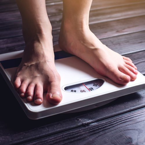 Women's feet are on mechanical scales for weight control Obesity Linked with Hearing Loss